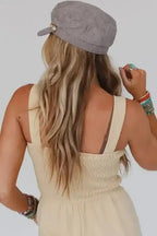 Back view of Beige Shirred Playsuit with button details, featuring a smocked bodice and sleeveless design for a light, breezy casual style.