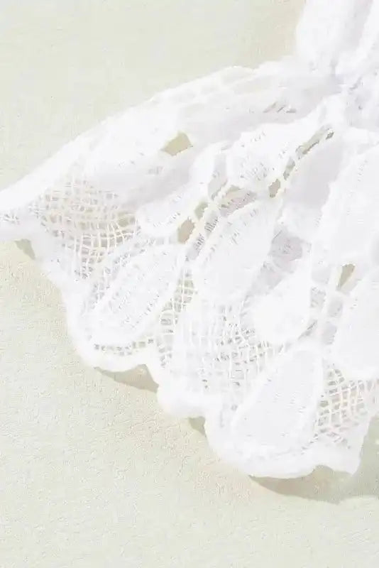Macro shot of lace cuff on beige embroidered mesh blouse. Intricate floral lace and teardrop embroidery enhance the feminine design.
