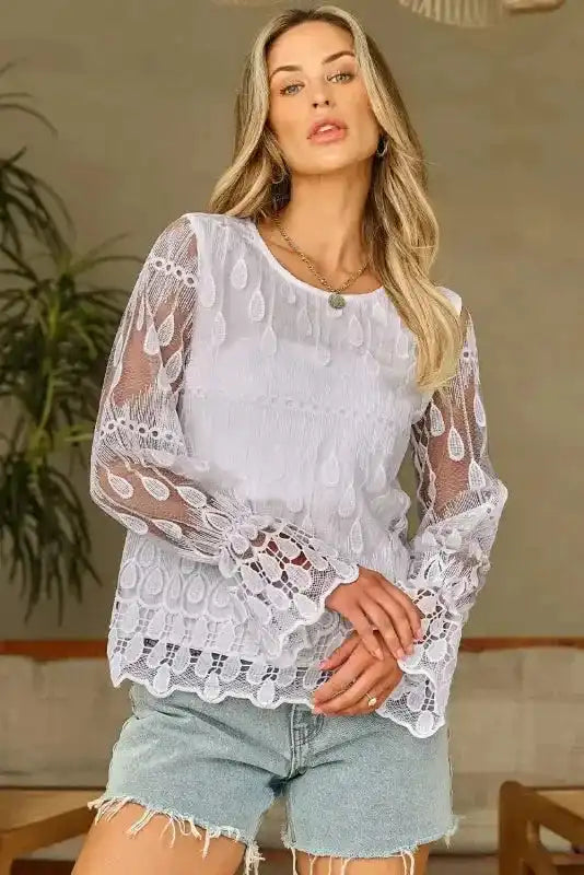 Fashion model poses in beige embroidered mesh blouse with flounce sleeves. A versatile top for both casual and semi-formal wear.