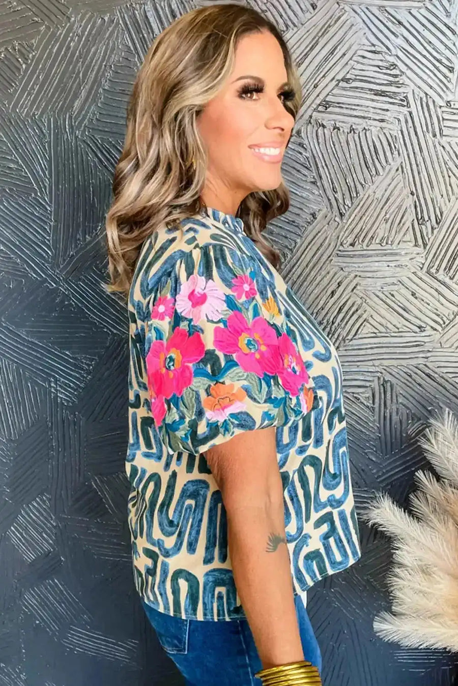 Side profile of women's embroidered top with puff sleeves and frilled neckline, highlighting bold floral embroidery and lightweight fabric.