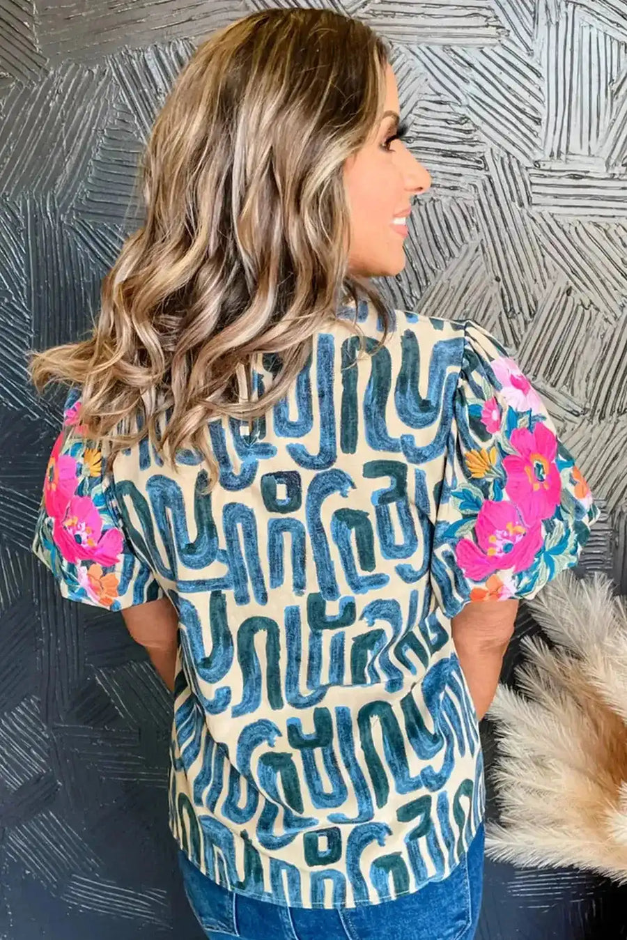Back view of women's multi-colour embroidered blouse with puff sleeves and frilled neck, showcasing vibrant floral embroidery and abstract design.