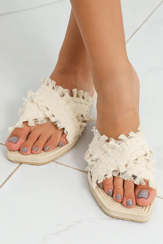 Beige tassel woven crossed straps flat slippers