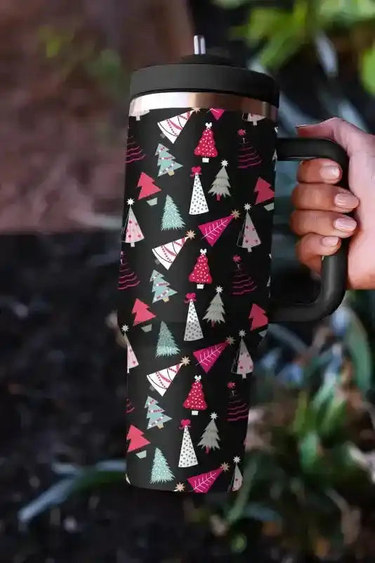 Holiday-themed black thermos cup with colorful cartoon tree pattern, includes straw and handle for easy carrying.
