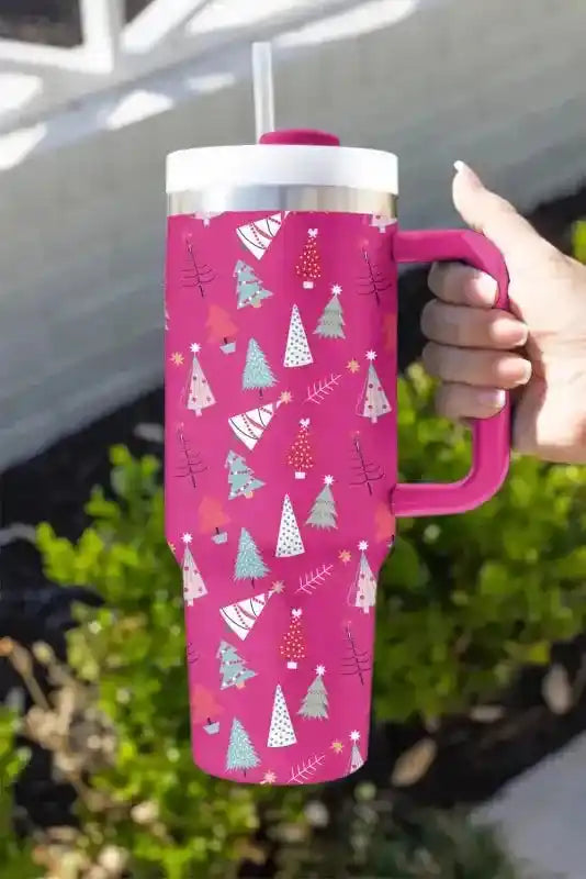 Bright pink thermos cup with cartoon Christmas tree pattern, ergonomic handle and straw for festive beverage enjoyment.