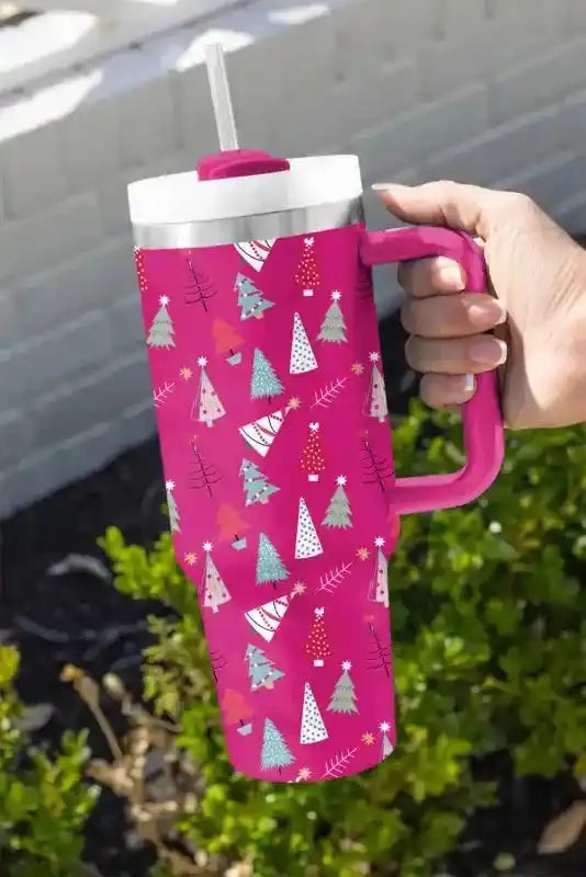 Holiday pink thermos cup with colorful cartoon tree print, perfect for hot or cold drinks with convenient handle and straw.