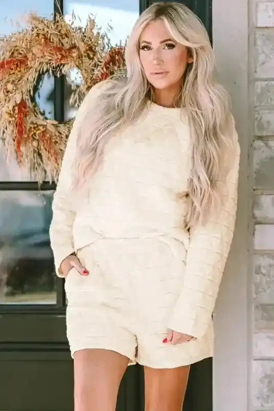 Woman modeling cream quilted shorts set with long sleeves, part of the modern style loungewear collection for cozy fashion.