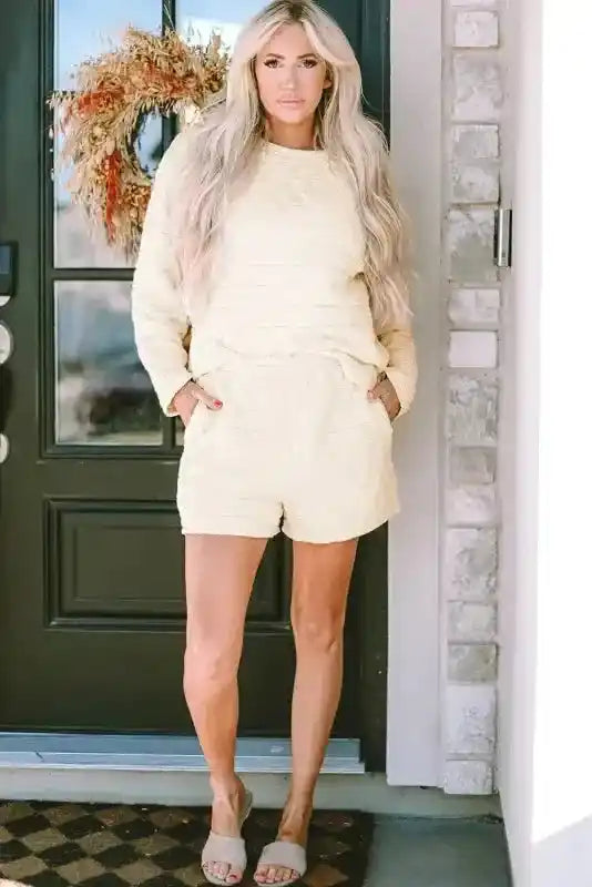 Full view of woman in cream quilted shorts set with long sleeves and cozy fit, ideal for modern loungewear fashion.