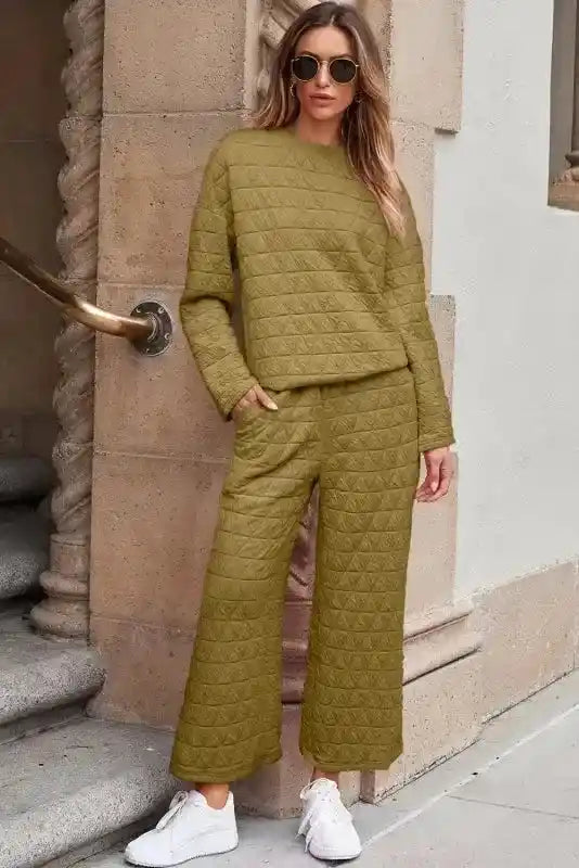 Woman wearing olive green quilted loungewear set with long sleeves and wide-leg pants, styled for modern cozy fashion.
