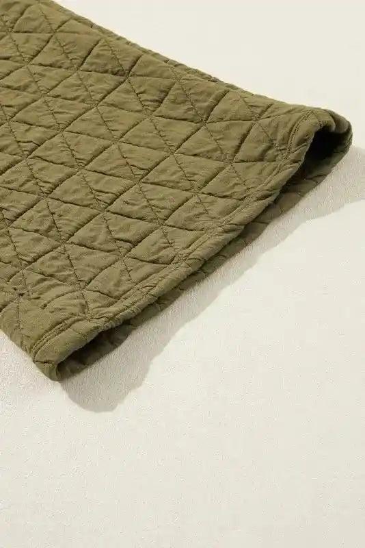 Close-up of olive green quilted sleeve from cozy loungewear set, highlighting soft texture and stitching.