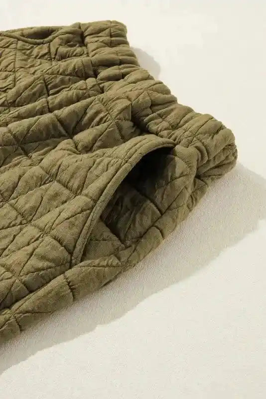 Detail of olive green quilted shorts pocket from modern loungewear set, designed for comfort and functionality.