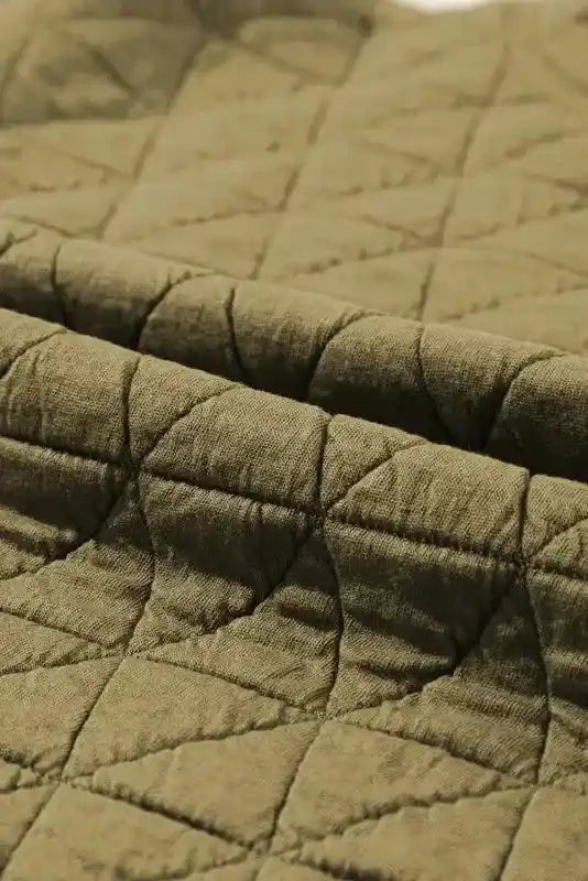 Close-up of olive green quilted fabric showing diamond stitching, part of the modern style quilted shorts set for loungewear.
