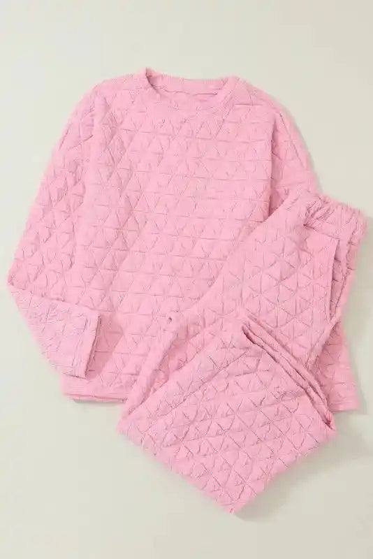 Flat lay of pink quilted loungewear set with long sleeves and shorts, designed for cozy modern fashion.