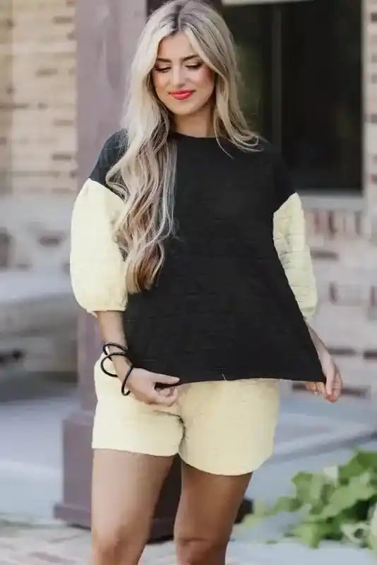 Trendy black quilted top with cream sleeves paired with matching cream shorts, ideal for stylish indoor lounging.