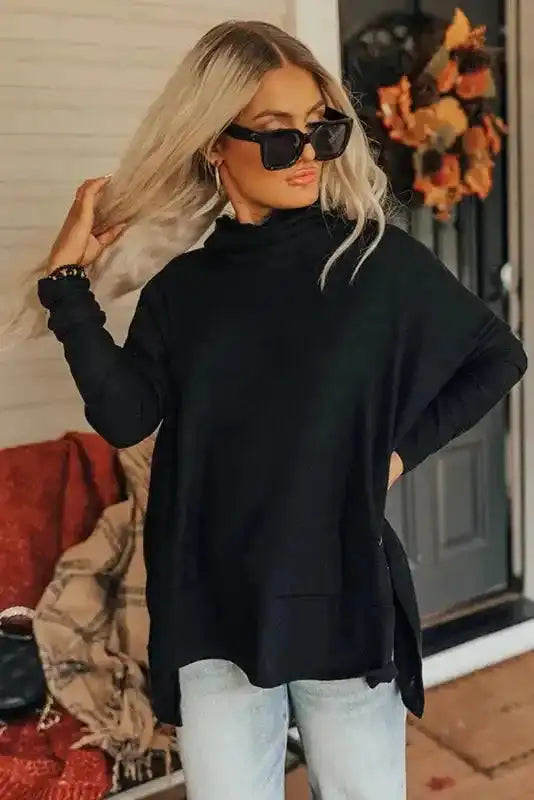Relaxed fit black cowl neck tunic top with side slits, styled for a cozy and chic casual look.