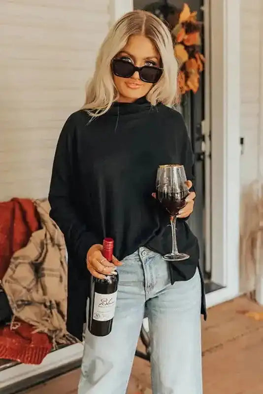 Lightweight black cowl neck tunic top styled with jeans, ideal for layering and casual fall or winter occasions.