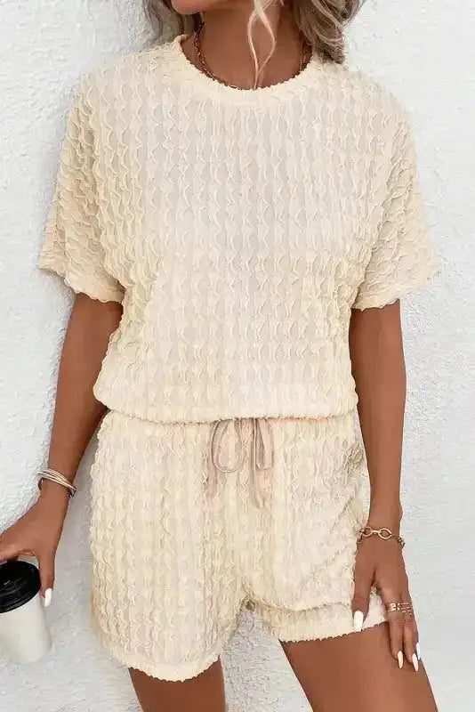 Women's beige co-ord set with textured short sleeve top and drawstring shorts. Ideal for summer holidays or casual wear.