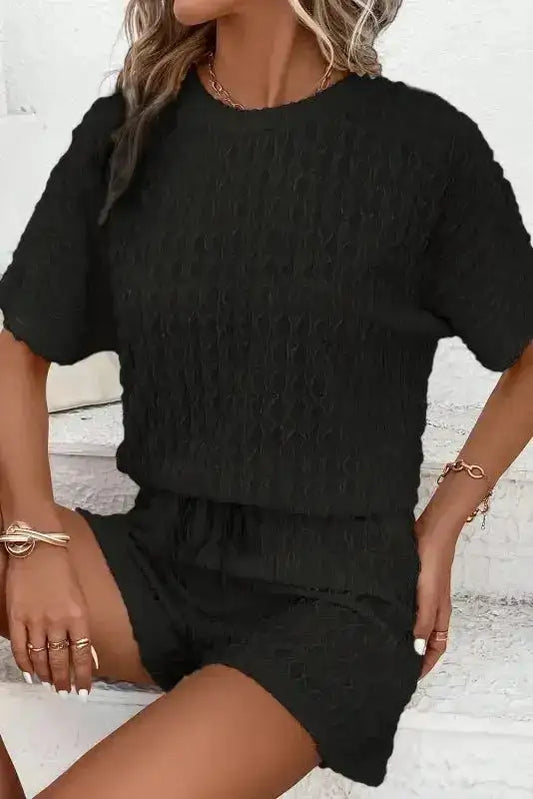 Black frill textured two-piece loungewear set with relaxed fit top and shorts. Lightweight and breathable for summer comfort.