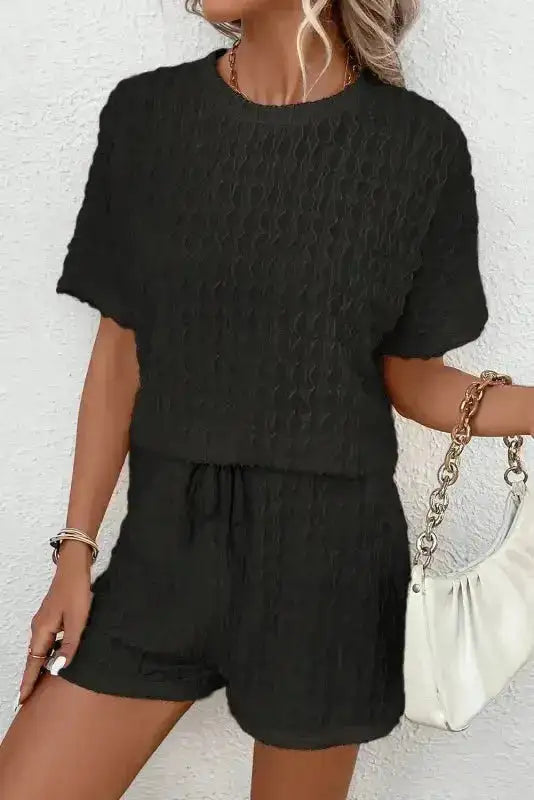 Women's black co-ord loungewear set with textured fabric and short sleeves. Great for casual outings or relaxing at home.