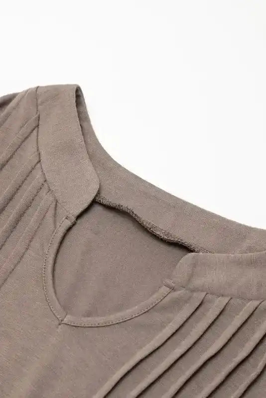 Detailed view of notched neckline and stitching on taupe Notched Pleat Puff Sleeve Shift T-Shirt Dress.