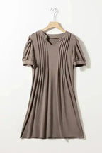 Taupe Notched Pleat Puff Sleeve Shift T-Shirt Dress on hanger, highlighting pleated front and puff sleeve details.