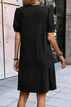 Back view of black Notched Pleat Puff Sleeve Shift T-Shirt Dress showing relaxed fit and short gathered sleeves.