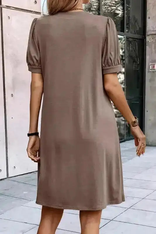Back view of taupe Notched Pleat Puff Sleeve Shift T-Shirt Dress showing simple, clean design and relaxed fit.