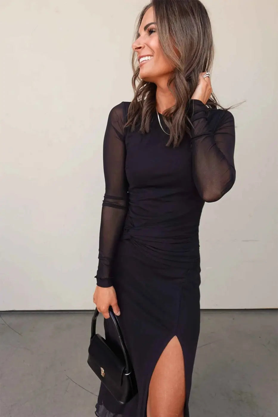 Smiling model in Black Sheer Sleeve Slit Party Dress featuring sheer sleeves and a high slit, perfect for elegant spring occasions.