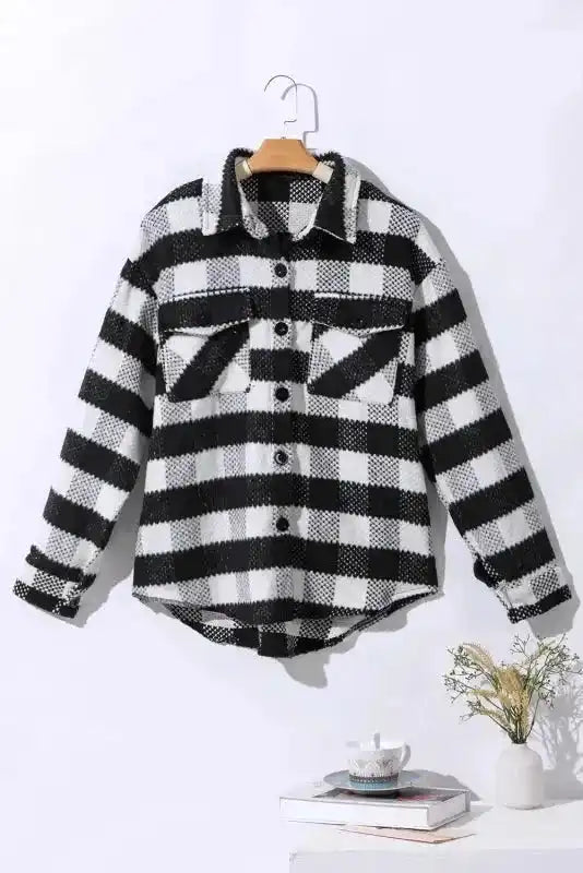 Black plaid shacket for winter outfits displayed on hanger, featuring button front and flap pockets for cozy seasonal style.