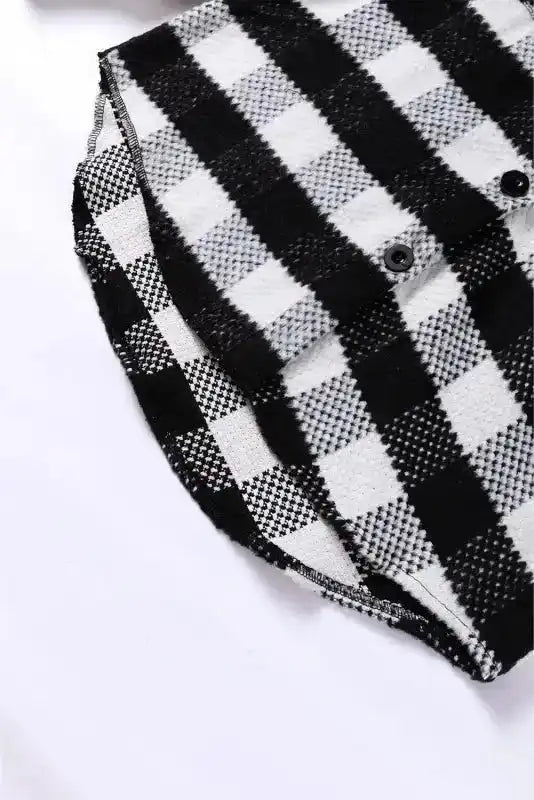 Hem detail of black plaid shacket for winter outfits, featuring curved edge and durable stitching for stylish layering.
