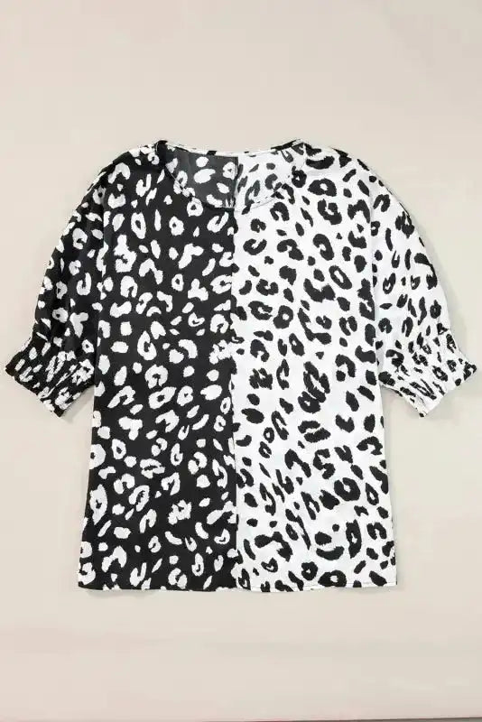 Flat lay of black and white leopard print plus size blouse with half sleeves and smocked cuffs, made of polyester fabric.
