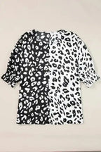 Flat lay of black and white leopard print plus size blouse with half sleeves and smocked cuffs, made of polyester fabric.