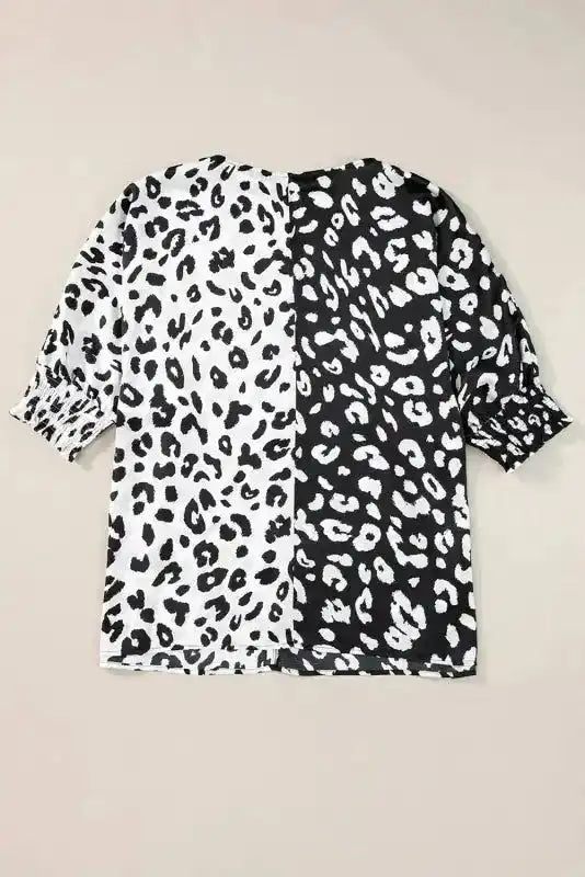 Back flat lay of plus size blouse with contrasting black and white leopard print and smocked half sleeves for summer wear.
