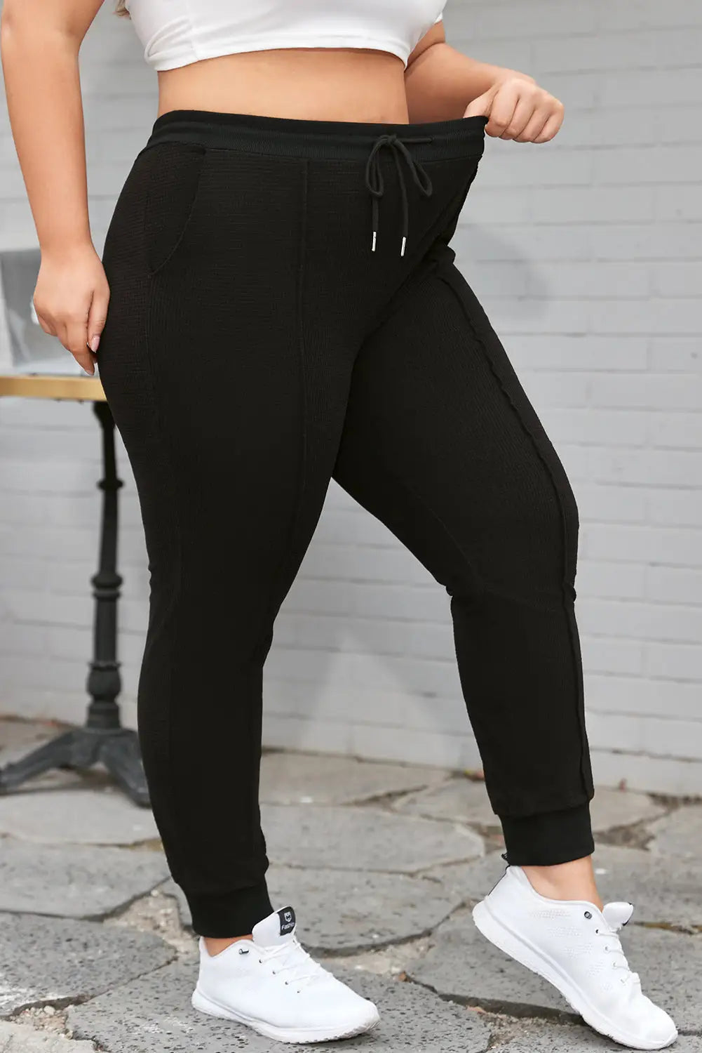 Black plus size textured exposed seam drawstring jogger pants