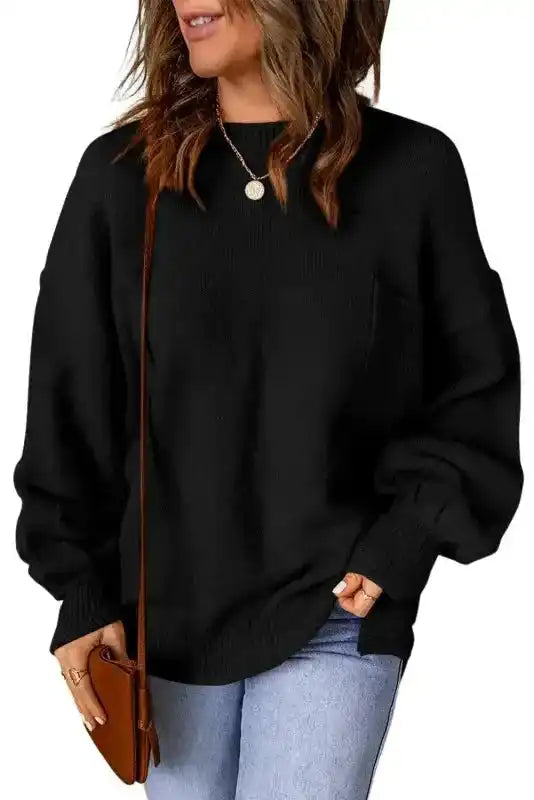 Black pocketed sweater with puffy sleeves and crew neck, styled for everyday wear with jeans and accessories, perfect for cooler seasons.
