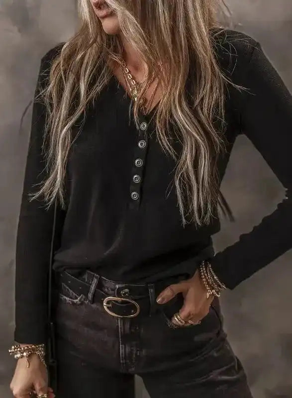 Model wearing Black Ribbed V‑Neck Long Sleeve Top with black jeans, showcasing a flattering fit and versatile style.