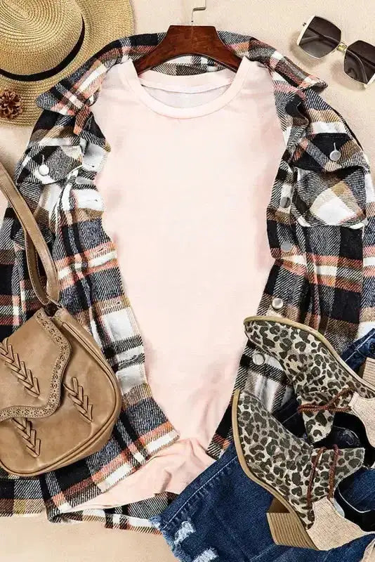 Flat lay of light pink plus size T-shirt styled with plaid shirt, leopard boots, and tan accessories for a cozy fall look.