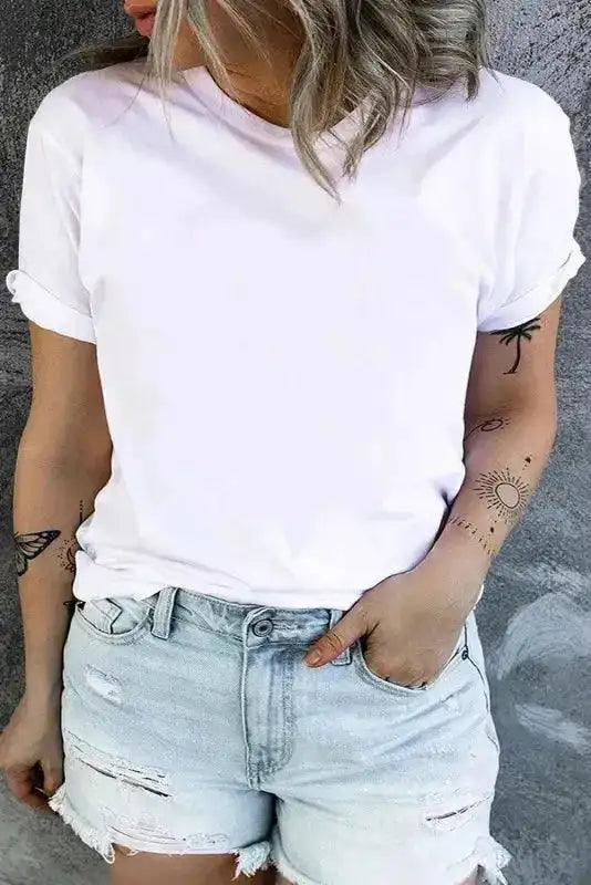 White plus size T-shirt with round neck and rolled sleeves, paired with distressed denim shorts for a relaxed summer outfit.