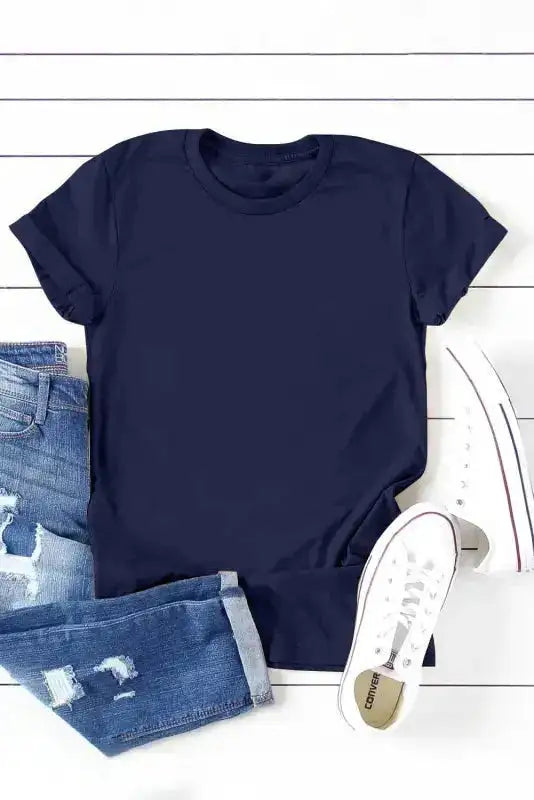 Flat lay of navy blue plus size T-shirt with rolled sleeves, styled with ripped jeans and white sneakers for a trendy casual outfit.