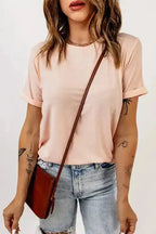 Light pink plus size T-shirt with round neck and rolled sleeves, styled with ripped jeans and a brown crossbody bag.