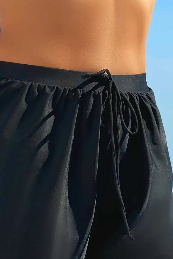 Close-up of black scalloped trim beach shorts waistband