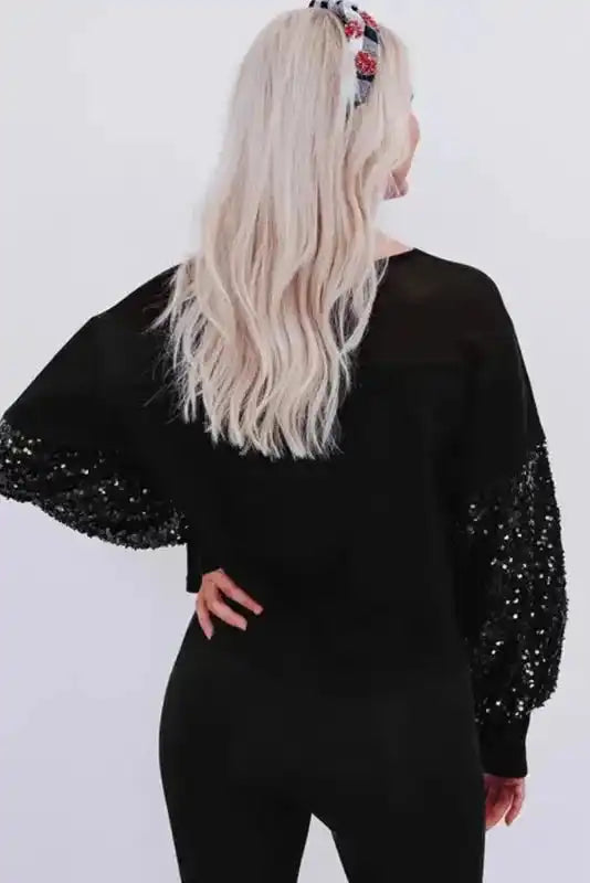 Back view of Black Sequin Patchwork Lantern Sleeve Blouse showing sheer upper panel and voluminous sequin sleeves, perfect for stylish events.