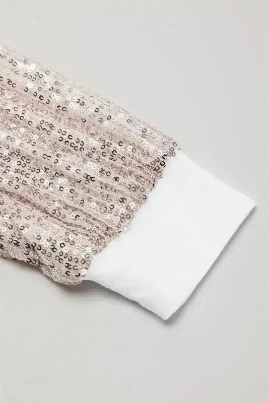 Close-up of rose gold sequin balloon sleeve with white cuff, highlighting the sparkle and texture of the party dress.