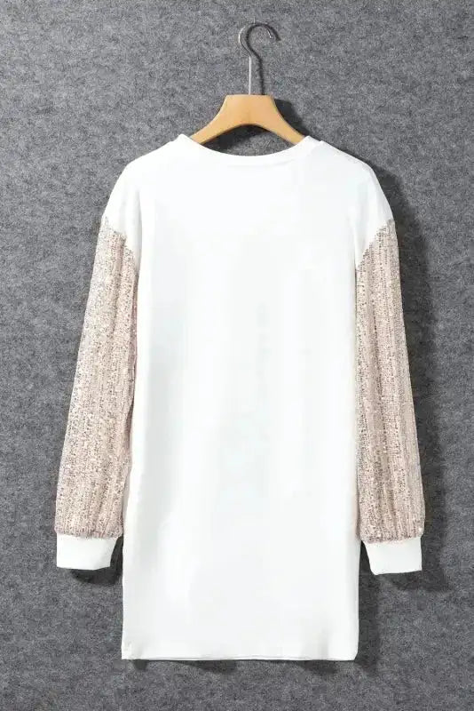 Back view of white mini dress with glittery sequin balloon sleeves, displayed on a hanger for product showcase.