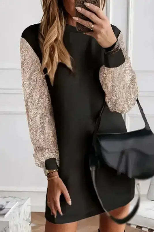 Elegant black mini dress with sequin balloon sleeves, styled with a black handbag for a sophisticated evening outfit.