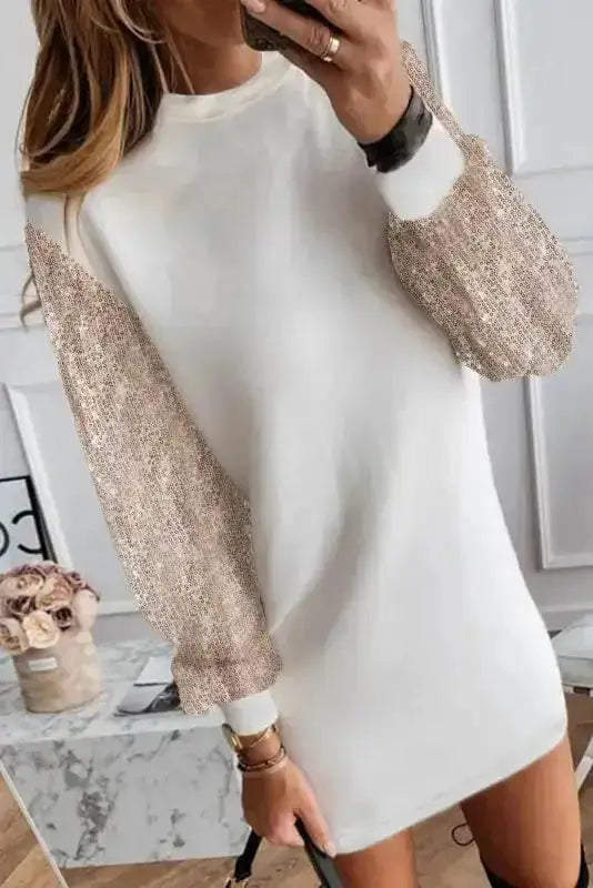 White shift mini dress featuring sparkling sequin balloon sleeves, perfect for festive events and stylish winter gatherings.