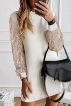 White shift mini dress with sequin balloon sleeves, styled with a black handbag for a chic party-ready look.