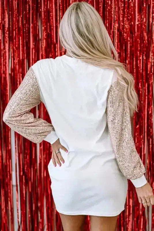 Back view of white shift mini dress with rose gold sequin sleeves, designed for festive and winter partywear.