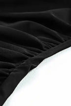 Detailed fabric texture of black tankini swimsuit showing soft, ruched material ideal for summer swimwear comfort.