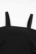 Close-up of square neckline and wide straps on black tankini swimsuit top, showcasing minimalist swimwear design.