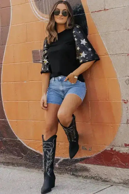 Stylish Black Star Sequin Top with star-studded sleeves, paired with shorts and boots for a bold summer statement look.